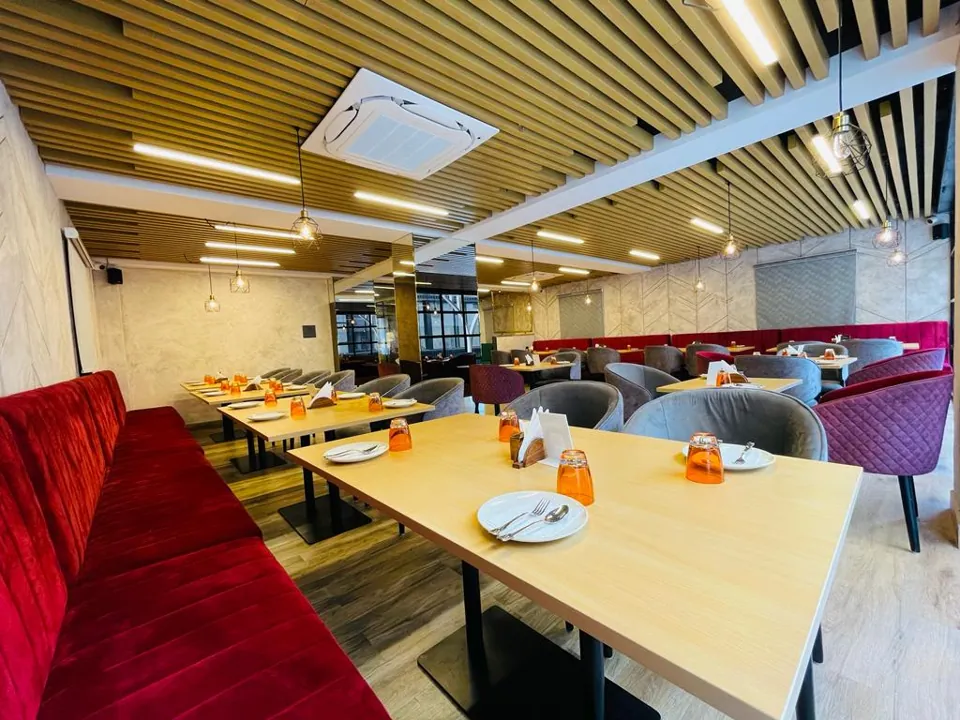 Delicia restaurant seating with wooden ceilings and red and grey upholstered chairs
